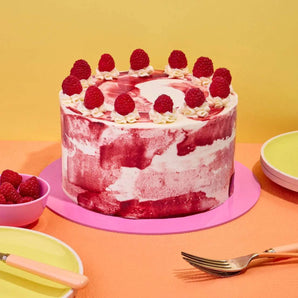 Raspberry Ripple Cake by Crumbs & Doilies with raspberry swirl icing and fresh raspberries on top.